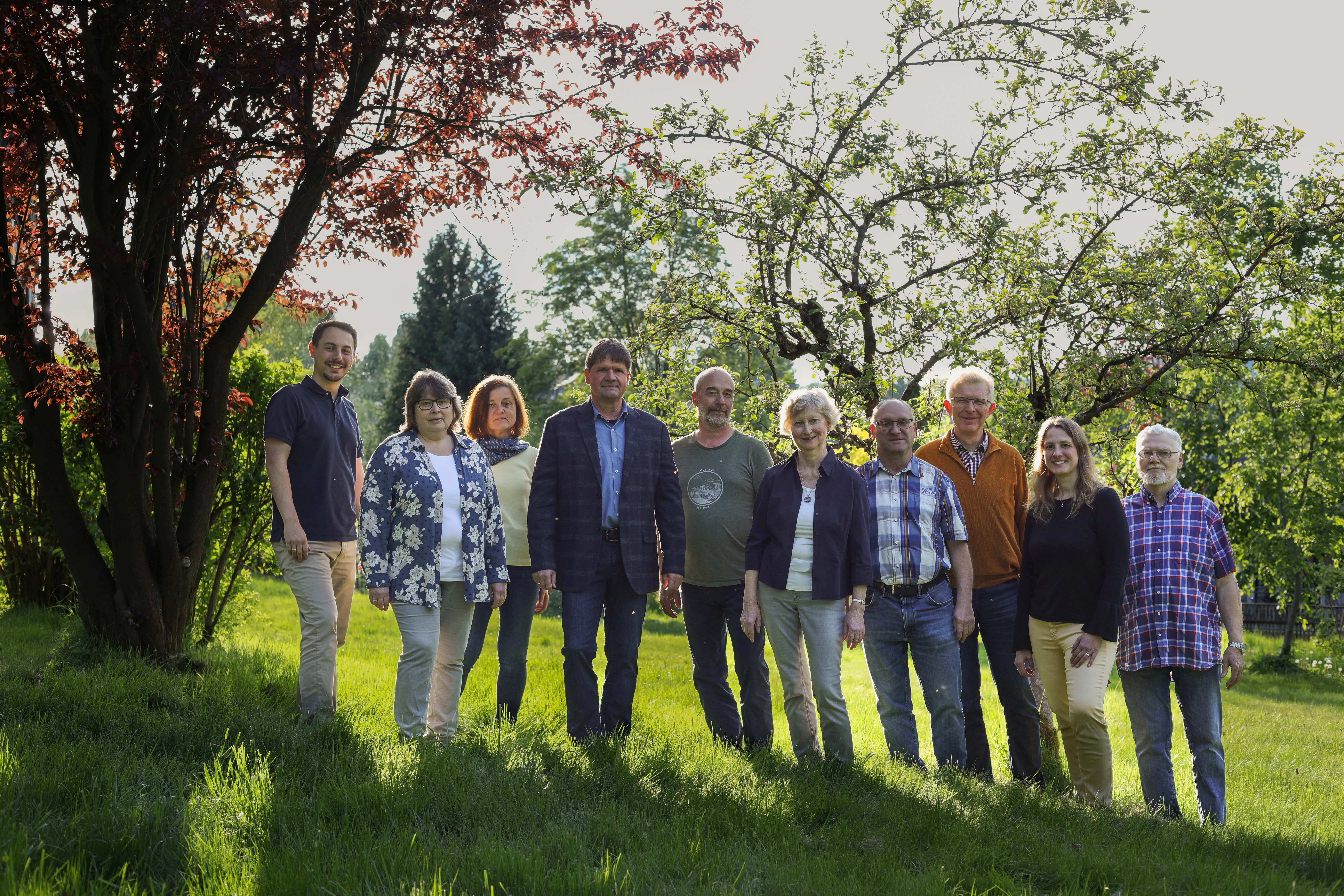 Porträt des Kirchenteams/Rats im Freien auf grasbewachsenem Hang.