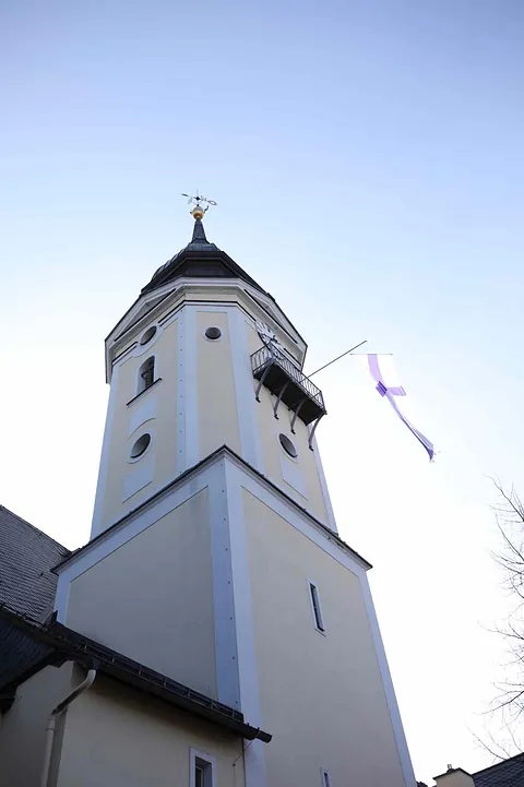 Kirchturm der Kirche "Zu unserer lieben Frauen" in Neustädtel bei Schneeberg, mit wehender Kirchenfahne vor klarem Himmel 